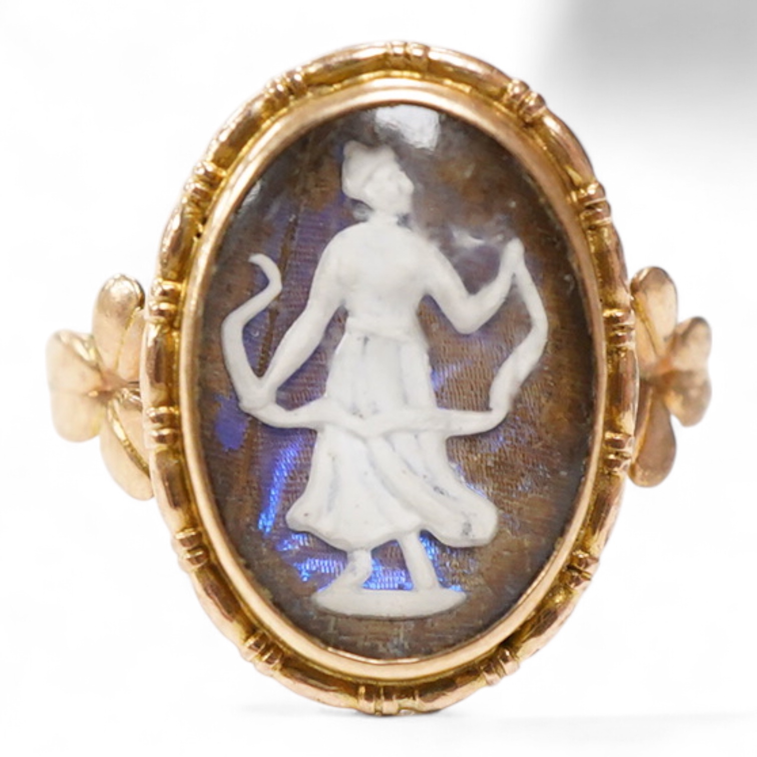 An early 20th century 9ct oval ring, decorated with the figure of a lady in relief, on a butterfly wing ground, beneath a glazed panel, size K, gross weight 2.3 grams.